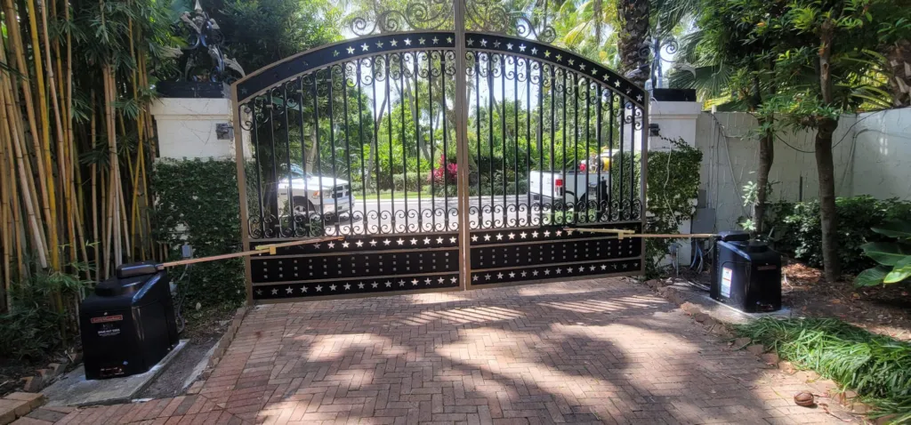 Arched iron double swing gate over a pavered driveway