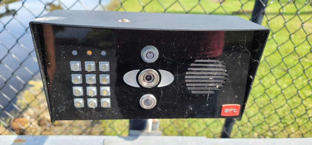 Gate keypad and intercom box mounted at an entrance